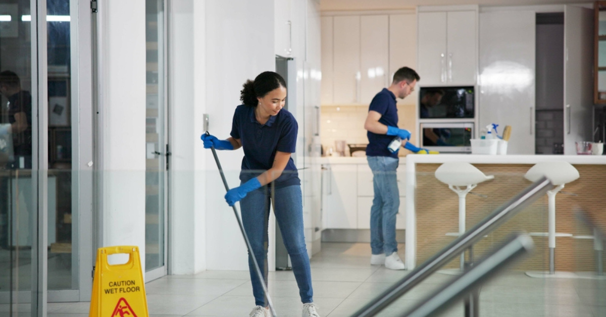 A woman is seen using a mop to clean the floor of a room, emphasizing her effort in keeping the space neat and organized.